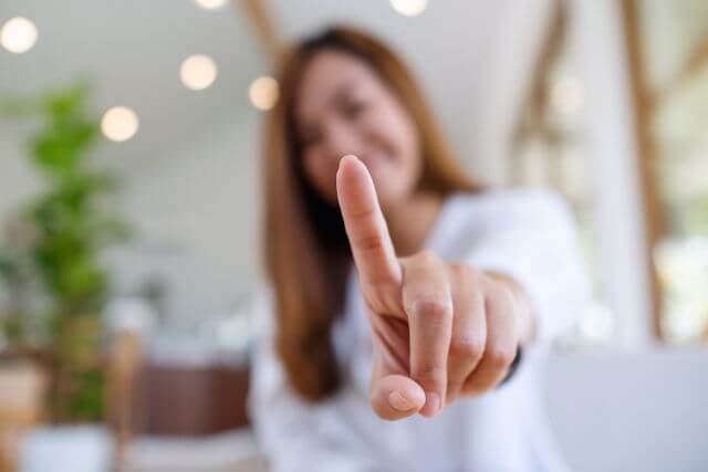 人差し指をこちらに向ける女性